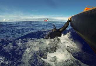 <p>Navio da Marinha australiana Ocean Shield reboca um mergulhador, durante operação de busca pelo avião da Malaysian Airlines, no Oceano Índico meridional, em  8 de abril</p>