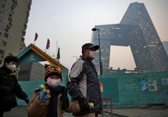 Moradores de Pequim usam máscaras devido à alta poluição do ar.