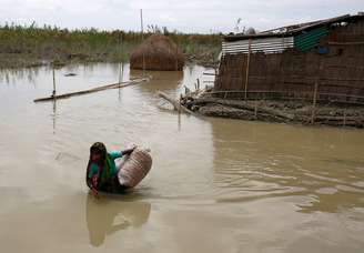 Mulher carrega pertences em área alagada em Gaibandha, Bangladesh 19/08/2017 REUTERS/Mohammad Ponir Hossain