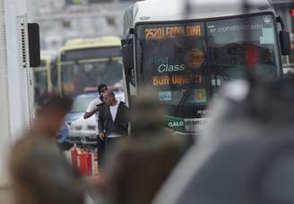 Refém encobre o sequestrador ao descer do ônibus na ponte Rio-Niterói.