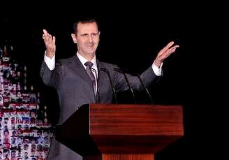 Bashar al-Assad saúda público durante discurso em teatro de Damasco neste domingo<br />