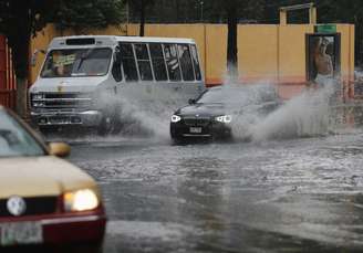 <p>Veículos dirigem por uma rua inundada após chuvas torrenciais que atingiram vários bairros da Cidade do México, na segunda-feira, 26 de maio</p>