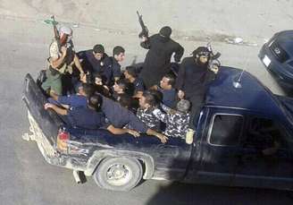 <p>Homens armados levam homens capturados, dois deles com uniformes da polícia, em Arsal, cidade muçulmana sunita do Líbano, perto da fronteira com a Síria, em 2 de agosto</p>