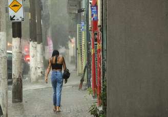 Mulher caminha na chuva na Al. Olga, no bairro da Barra Funda.