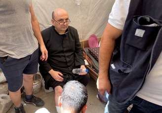 Padre Gabriele Romanelli recebe atendimento médico após ataque de Israel a igreja em Gaza 17/7/2025
