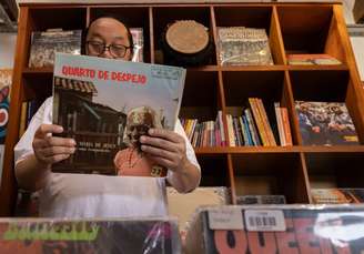 Paulo Sakae Tahira, proprietário da loja de discos Patuá Discos, com o álbum 'Quarto de Despejo' de Carolina Maria de Jesus