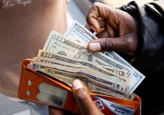 Pessoa exibe notas de dólar americano após sacar dinheiro em um banco em Harare, Zimbábue, 9 de julho de 2019. REUTERS/Philimon Bulawayo