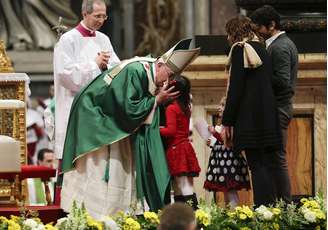 Papa Francisco beija uma criança durante missa dominical na Basílica de São Pedro