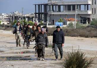 Combatentes rebeldes caminham em torno da base al-Hamidyeh, na província de Idlib, na Síria. 15/12/2014.