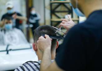 Cabeleireiro Kestir Gitsin corta cabelo de cliente após retorno da quarentena por coronavírus em Colonha, Alemanha
 4/4/2020 REUTERS/Thilo Schmuelgen