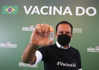 João Doria, governador de São Paulo, posa com uma dose da vacina Coronavac, aprovada por unanimidade pela Anvisa