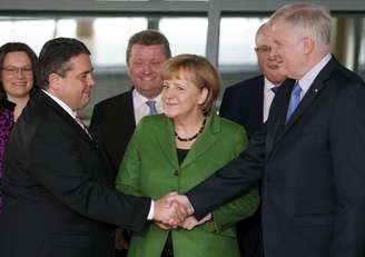 Merkel entre Horst Seehofer (dir.) e Sigmar Gabriel
