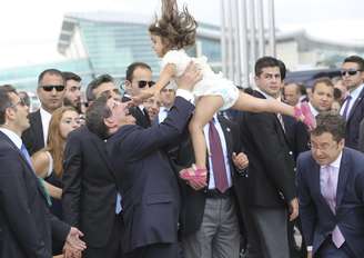 <p>O primeiro-ministro turco, Ahmet Davutoglu (ao centro), joga para o alto a filha do Cônsul Geral da Turquia em Mossul, Ozturk Yilmaz, ao comemorar a chegada dos reféns do Estado Islâmico </p><p> </p>