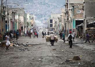 Haitianos caminham por uma das principais ruas comerciais durante um protesto contra o governo, em Porto Príncipe, no Haiti. 09/02/2015