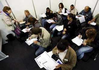 Desempregados preenchem fichas de inscrição em busca de emprego em São Paulo