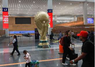 Passageiros passam por réplica gigante do troféu da Copa do Mundo no Aeroporto Internacional da Cidade do México 
 18 de maio de 2026    REUTERS/Henry Romero