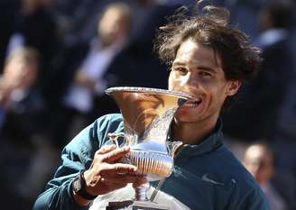 <p>Em gesto tradicional, espanhol Rafael Nadal finge morder o troféu do Masters 1000 de Roma. Número 5 do mundo, o tenista venceu o suíço Roger Federer na final da competição, neste domingo, por 2 sets a 0, com parciais de 6/1 e 6/3</p>