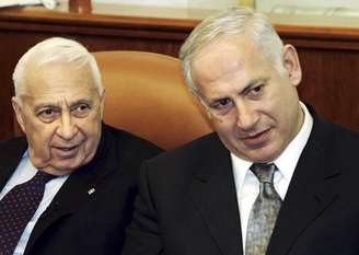 <p>Ariel Sharon (esq.) e o então ministro das Finanças Benjamin Netanyahu participam de encontro em 2005</p>