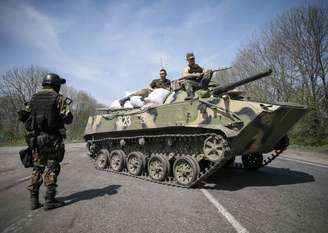 <p>Soldados ucranianos sentam em cima de um veículo blindado em um posto de controle, nos arredores da cidade de Slaviansk, neste domingo, 27 de abril</p>