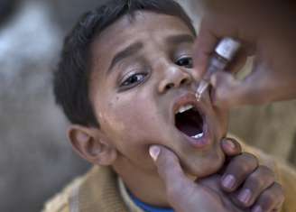<p>Criança é vacinada contra a poliomielite por um profissional de saúde em Islamabad, Paquistão, em 25 novembro de 2013</p>