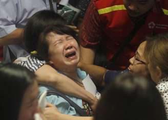 <p>Parentes de passageiros que estavam no avião da AirAsia choram ao saber que corpos foram encontrados no Mar de Java</p>