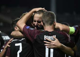 Higuaín comemora seu gol abraçado aos seus companheiros (Foto: JOHN THYS / AFP)