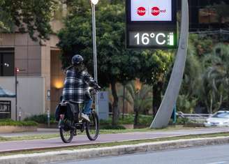 Ciclista se protege do frio na região da Avenida Faria Lima, em São Paulo, na tarde de quinta-feira: frio será menos intenso no final de semana.
