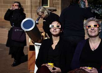 Mulheres usam óculos de proteção para acompanhar o eclipse em Sydney