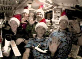 Tripulação do ônibus espacial Discovery comemorou o Natal de 1999 com gorros de Papai Noel