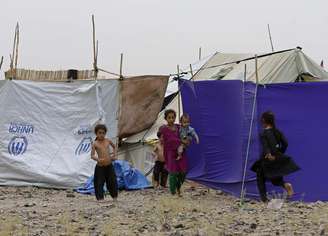 <p>Crianças paquistanesas brincam do lado de fora da sua tenda em um campo de refugiados na província de Khost, em 2 de julho. A Autoridade de Gestão das Catástrofes afirma que 43% dos deslocados internos do Paquistão são crianças</p><p> </p>