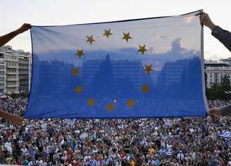 Manifestantes concentrados em frente ao parlamento grego seguram bandeira da União Europeia 18/06/ 2015.
