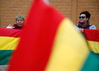 Mulherres são vistas entre bandeiras da Bolívia. 28/12/2019. REUTERS/David Mercado 