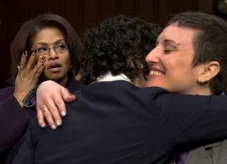 <p>A ex-especialista do Exército americano BriGette McCoy seca as lágrimas enquanto a ex-sargento Rebekah Havrilla abraça uma antiga oficial da Marinha após prestar depoimento</p>