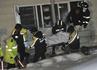 Equipe de resgate retira o corpo de um estudante universitário dos escombros do resort