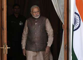 <p>Primeiro-ministro da Índia, Narendra Modi sai de uma sala de reuniões para receber o seu homólogo butanes, Tshering Tobgay, antes do início do encontro bilateral em Nova Delhi, em 27 de maio</p>