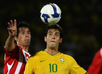 Victor Céceres e Kaká disputam bola em partida válida pela Eliminatórias da Copa de  2010. Dunga era o técnico