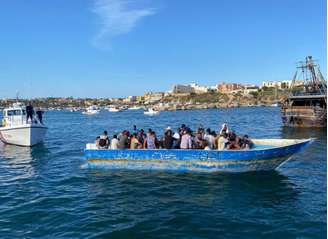 Barco com migrantes na costa de Lampedusa, sul da Itália