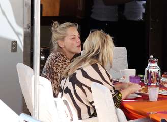 Sharon Stone foi fotografada sem maquiagem ao tomar café da manhã com amigos no barco de Roberto Cavalli, em Cannes, na França