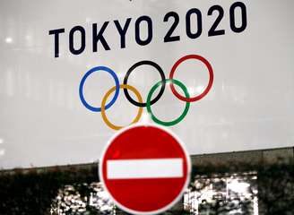 Cartaz da Olimpíada Tóquio-2020 atrás de sinal de trânsito no Japão
24/03/2020 REUTERS/Issei Kato 