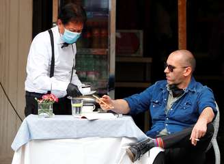 Homem é servido por garçom com máscara de proteção em restaurante de Roma
18/05/2020 REUTERS/Guglielmo Mangiapane