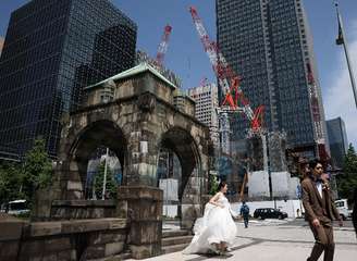 Casal tira fotos de seu casamento perto de um canteiro de obras em Tóquio
 19 de maio de 2026.  REUTERS/Issei Kato