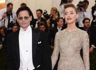 Ao lado do namorado Johnny Deep, no Festival de Cannes 2014, Amber Heard brilha com batom vermelho-escuro e brilho nos olhos, como do vestido 