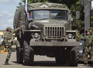 <p>Armadas separatistas pró-russas movimentam-se dentro de um posto da Guarda Nacional ucraniana capturado na cidade de Donetsk, em 28 de junho</p>