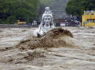 Águas deixam quase submersa uma estátua de um ídolo hindu em Rishikesh