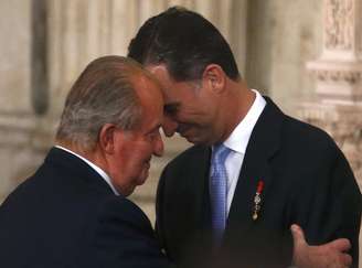 <p>O rei da Espanha, Juan Carlos, e seu filho, príncipe Felipe, se abraçam durante cerimônia de assinatura do ato de abdicação no Palácio Real em Madrid, em 18 de junho</p>