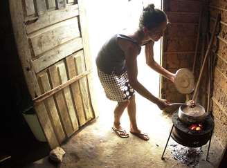 Mulher prepara comida em seu barraco, em favela localizada em Teresina, no Piauí. Foto: Roberto Castro / ESTADÃO.