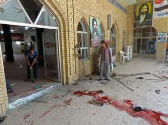 Iraquianos limpam mesquita próxima a Badgá, onde sete pessoas morreram após explosão de quatro morteiros