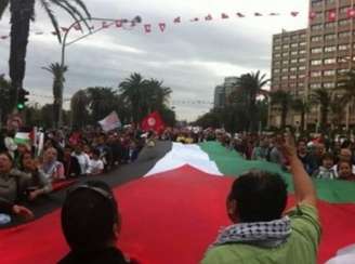 <p>A multidão exibe a bandeira palestina durante manifestação na Tunísia, em 11 de julho</p>