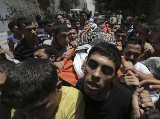<p>Palestinos carregam o corpo de um jihadista islâmico morto em um ataque aéreo israelense em um campo de refugiados de Jabaliya, no norte da Faixa de Gaza, em 12 de julho</p><p> </p>