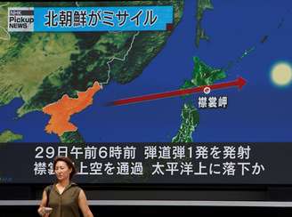 Telão em Tóquio mostra o percurso do míssil norte-coreano que passou sobre o Japão